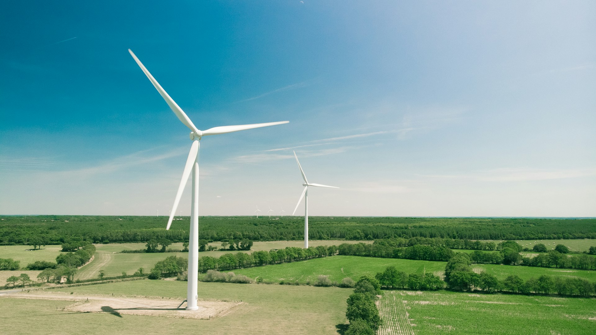 White wind turbines in a landscape of green mountains in northern Spain